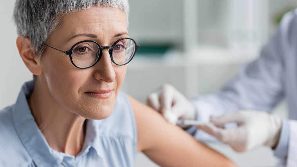Dame met grijs haar krijgt vaccin