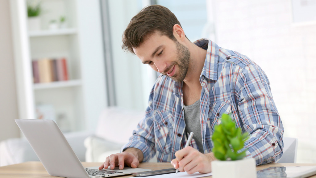 un homme travaille à son bureau à domicile avec un ordinateur portable