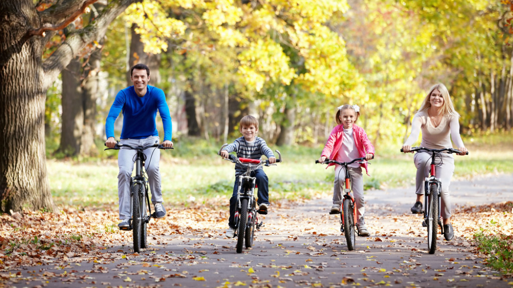 Famille qui fait du vélo dans un décor automnal