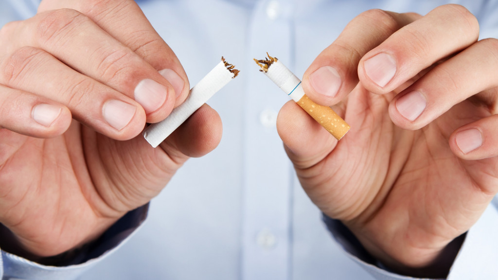homme casse la cigarette en deux