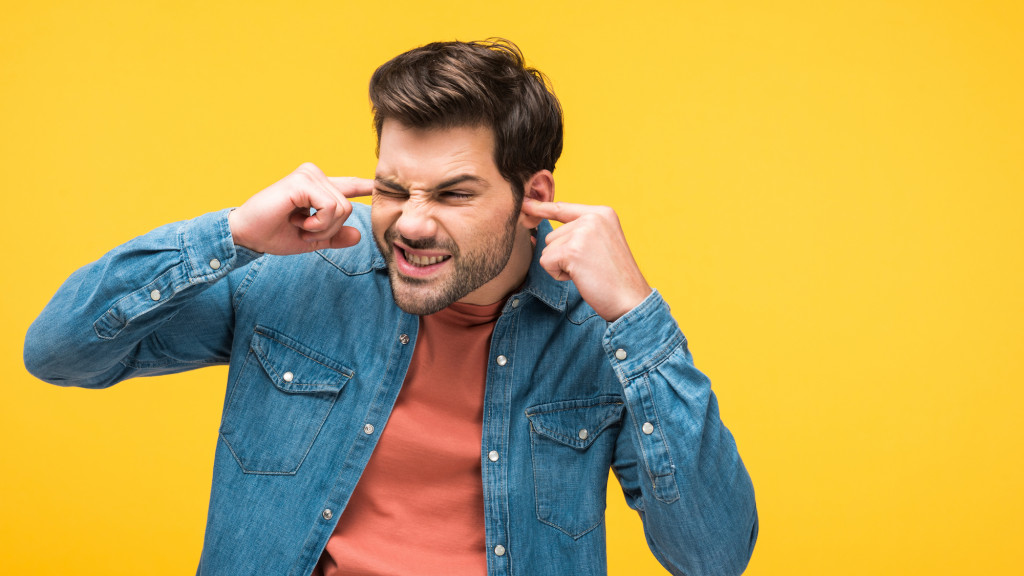 Man met vingers in zijn oren