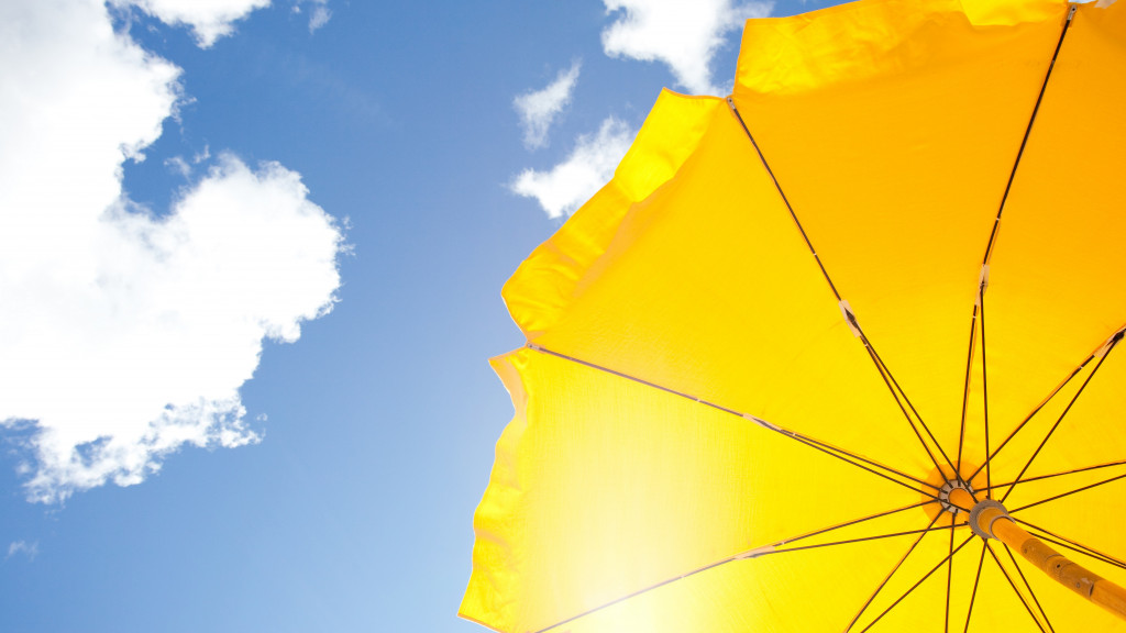 gele parasol voor blauwe lucht met wolken