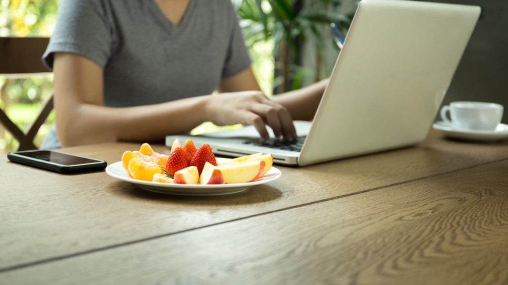 Etudiante qui mange des fruits en étudiant