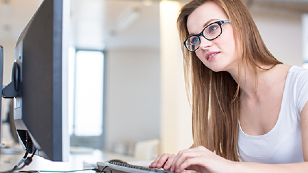 Vrouw surft op desktop in bibliotheek