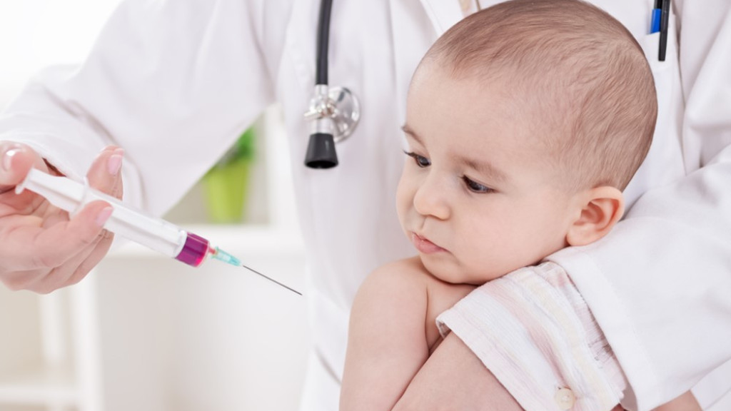 een arts die een injectie aan een kind geeft