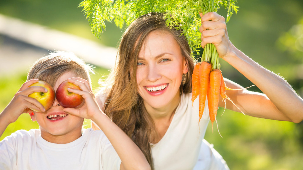 vrouw draagt wortels en kind met appels