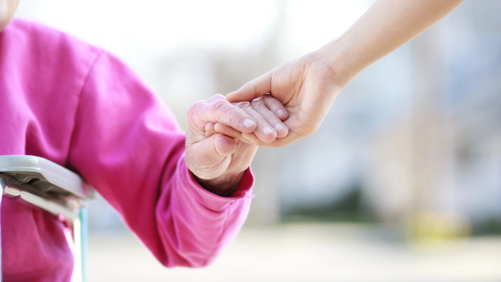 Une jeune qui aide une personne âgée