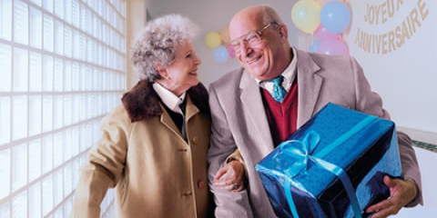 couple âgé avec un cadeau. Profitez de chaque moment grâce à la vaccination! 