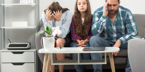 Jonge mantelzorger zit tussen vader en moeder