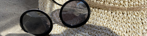 lunettes de soleil et chapeau sur le sable