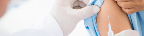 Médecin qui injecte un vaccin dans le bras du patient