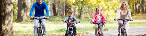 Famille qui fait du vélo dans un décor automnal