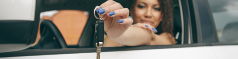 vrouw in de auto met autosleutel banner