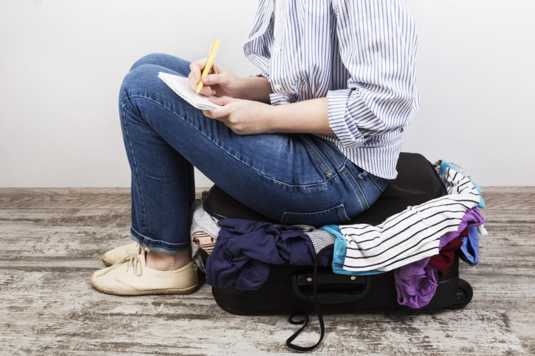 Check list reis vrouw zit op koffer