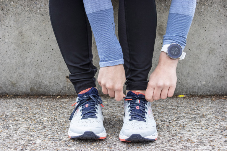 Meisje knoopt de veters van haar loopschoenen