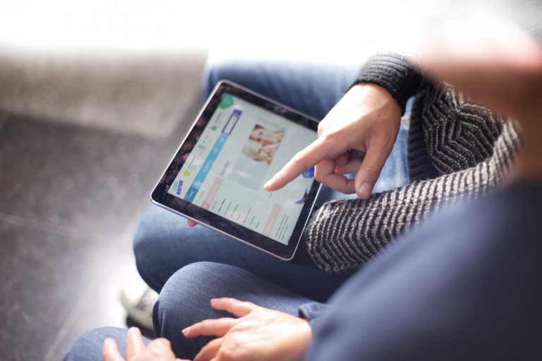 Iemand surft op de webshop van Zorgboetiek op een tablet.