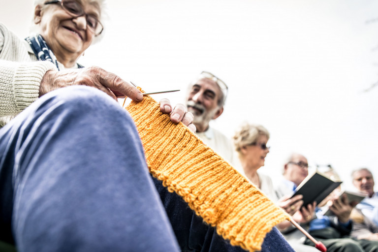 Oude dame met breiwerk en andere senioren