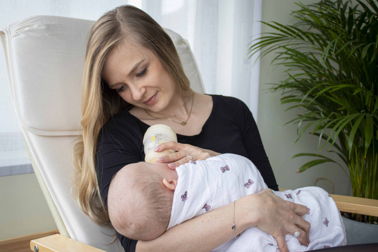 Jonge mama geeft flesvoeding aan haar baby.