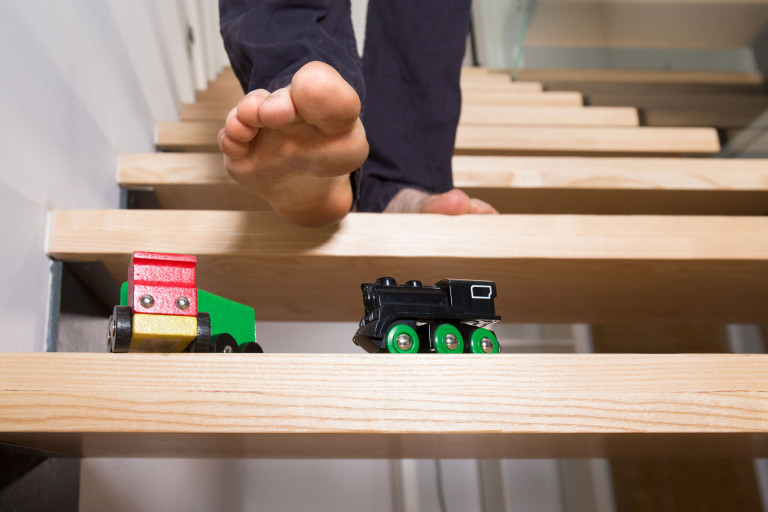 Voet boven speelgoed op trap