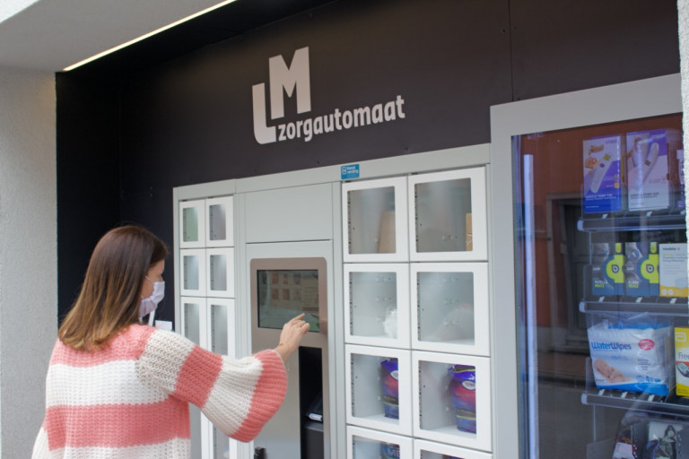 vrouw haalt iets uit zorgautomaat