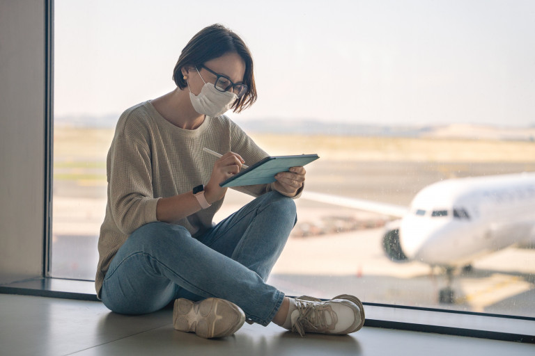 vrouw met mondmasker op luchthaven