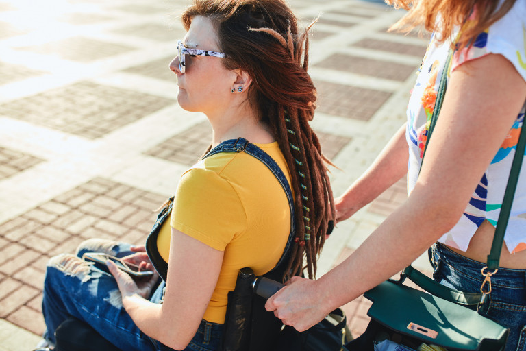 Jonge vrouw in rolstoel met zus
