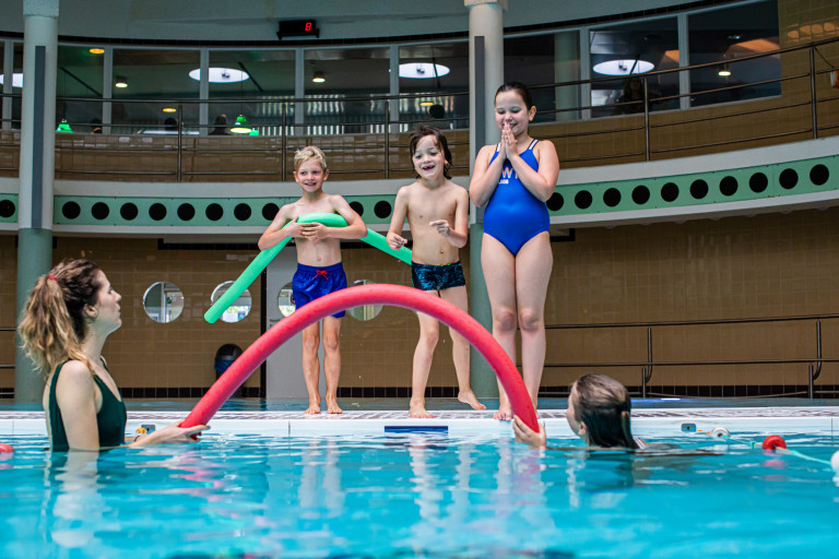 Kinderen staan aan de rand van het zwembad