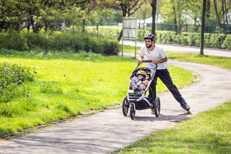 Vader skeelert met buggy en dochter