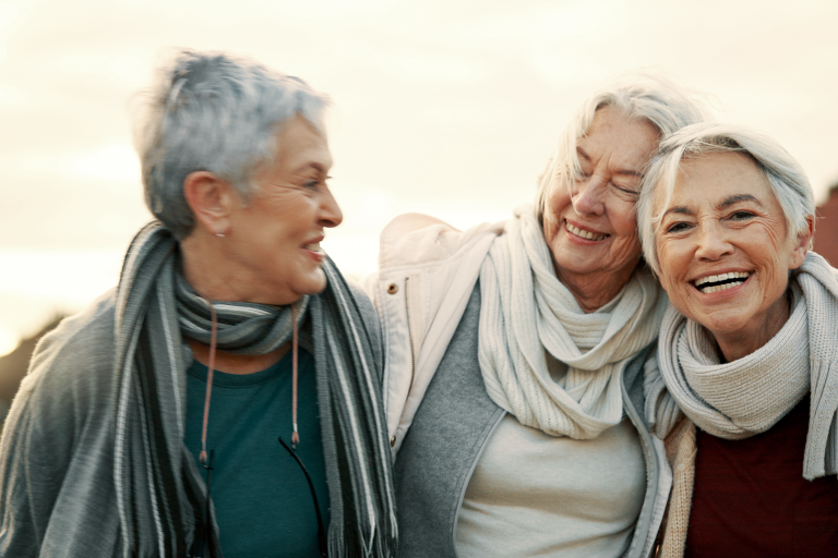 3 oudere vrouwen, vriendinnen lachen buiten in de herfst