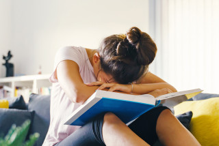 Banner studente met hoofd in de boeken