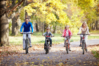Famille qui fait du vélo dans un décor automnal