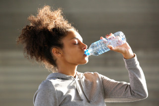Fille boit de l'eau après l'exercice