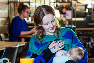 Femme qui allaite son bébé dans un café
