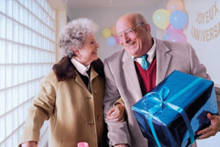couple âgé avec un cadeau. Profitez de chaque moment grâce à la vaccination! 