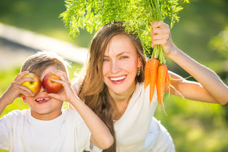 vrouw draagt wortels en kind met appels
