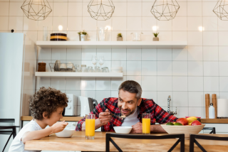 Vader en zoon zitten samen aan ontbijttafel
