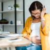 une femme enceinte travaille sur un ordinateur portable